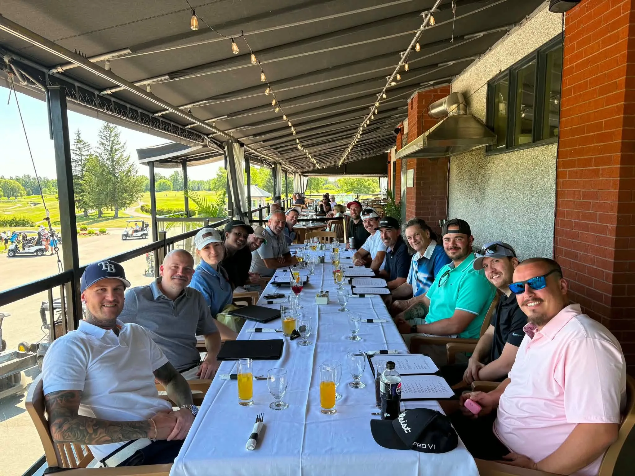 Des membres de l’équipe des Cheminées CLC attablés sur une terrasse lors du tournoi de golf CLC